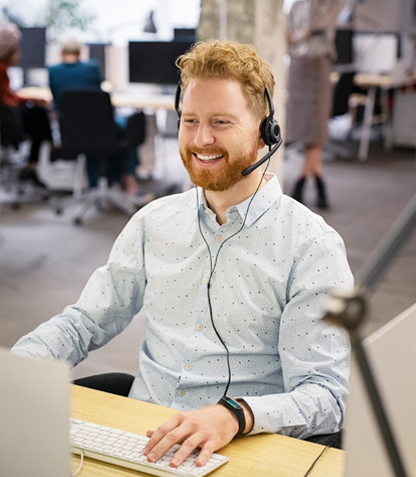 A man wearing a telephone headset and smiling