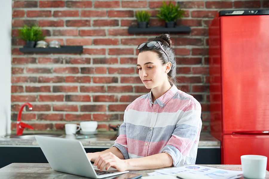 woman in striped jumper on laptop working from home